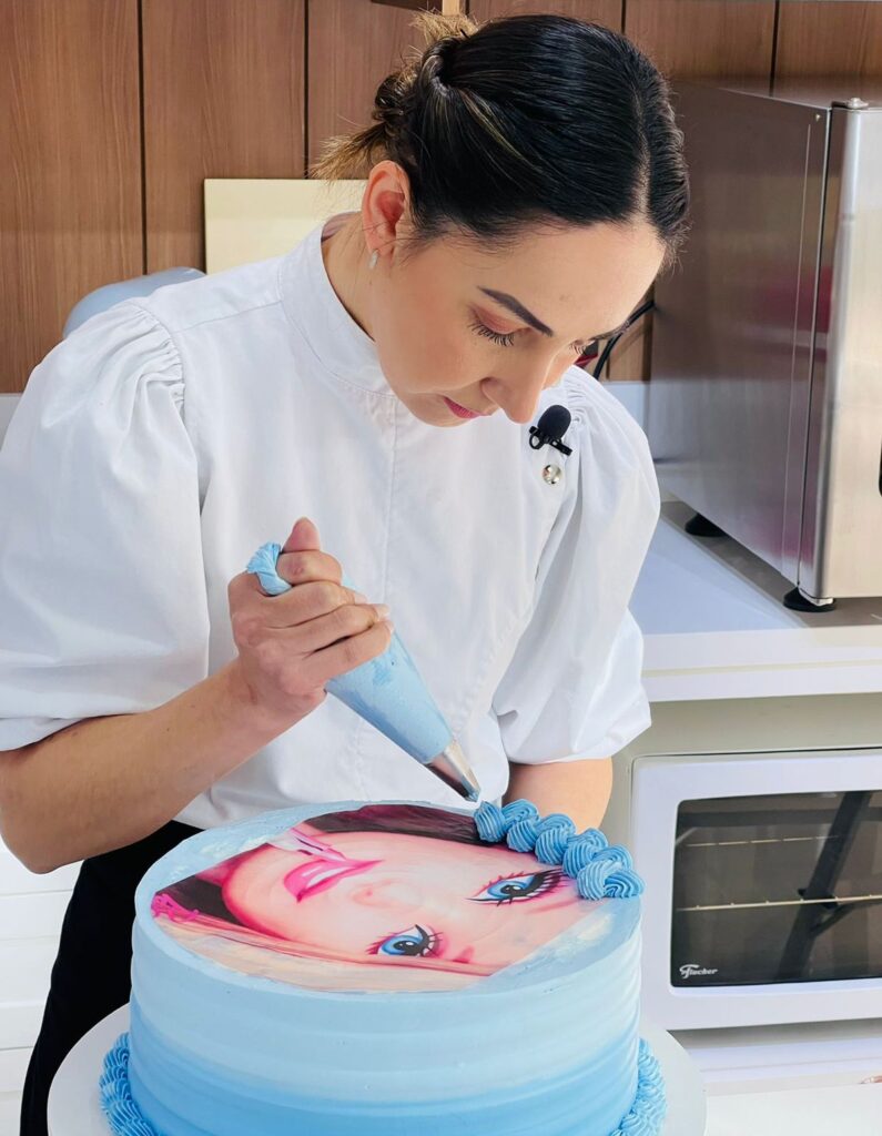 Marrara confeitando bolo artístico